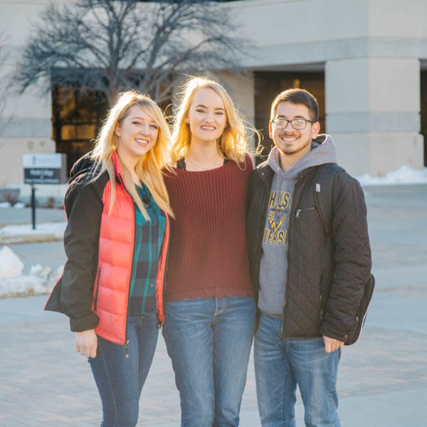 Student standing in front of Tomanek Hall