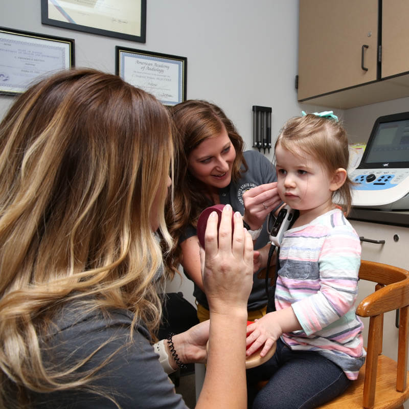 mentors of Department of Health and Behavioral studies checking hearing disorder with a kid 2