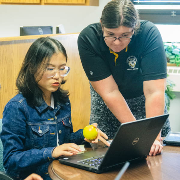 a staff member helping an international student enroll her class