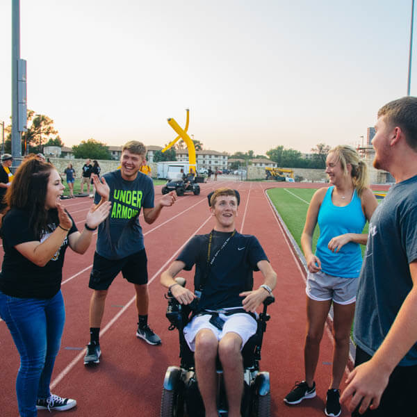 students helping with disabled student play in the Levis Track & Field