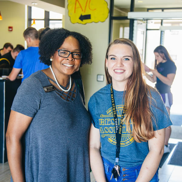 a student standing with a faculty member