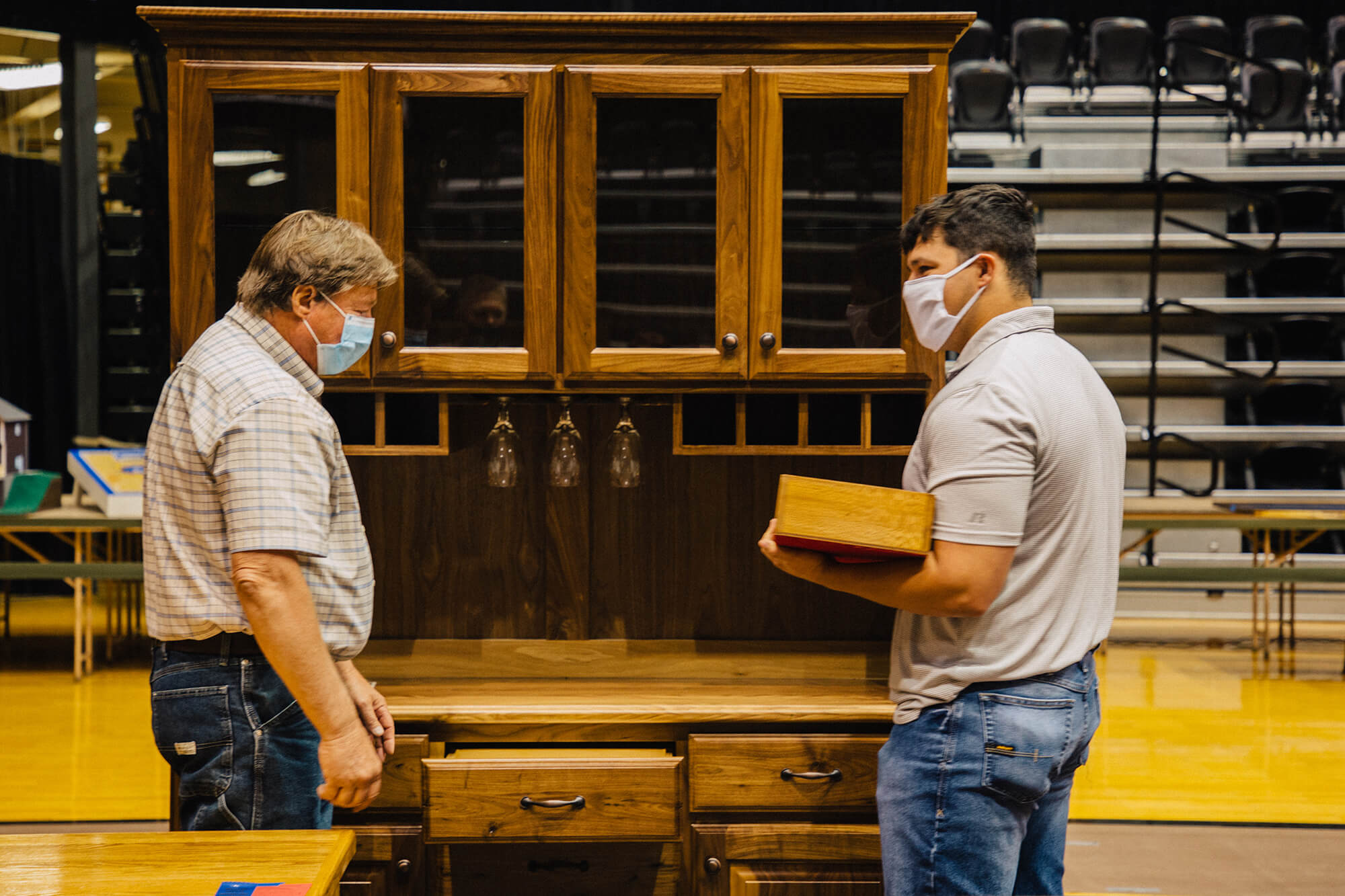 Fort Hays State University senior James Little, right, assists judge Richard Rome at the 2021 Western Kansas Technology Education Fair.