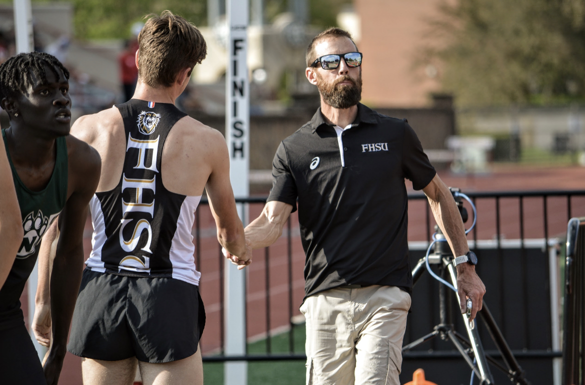 Jason McCullough, right, head track and field coach at Fort Hays State University, congratulates Tiger runner Ethan Lang after a race this season. Photo by Camryn Plemons