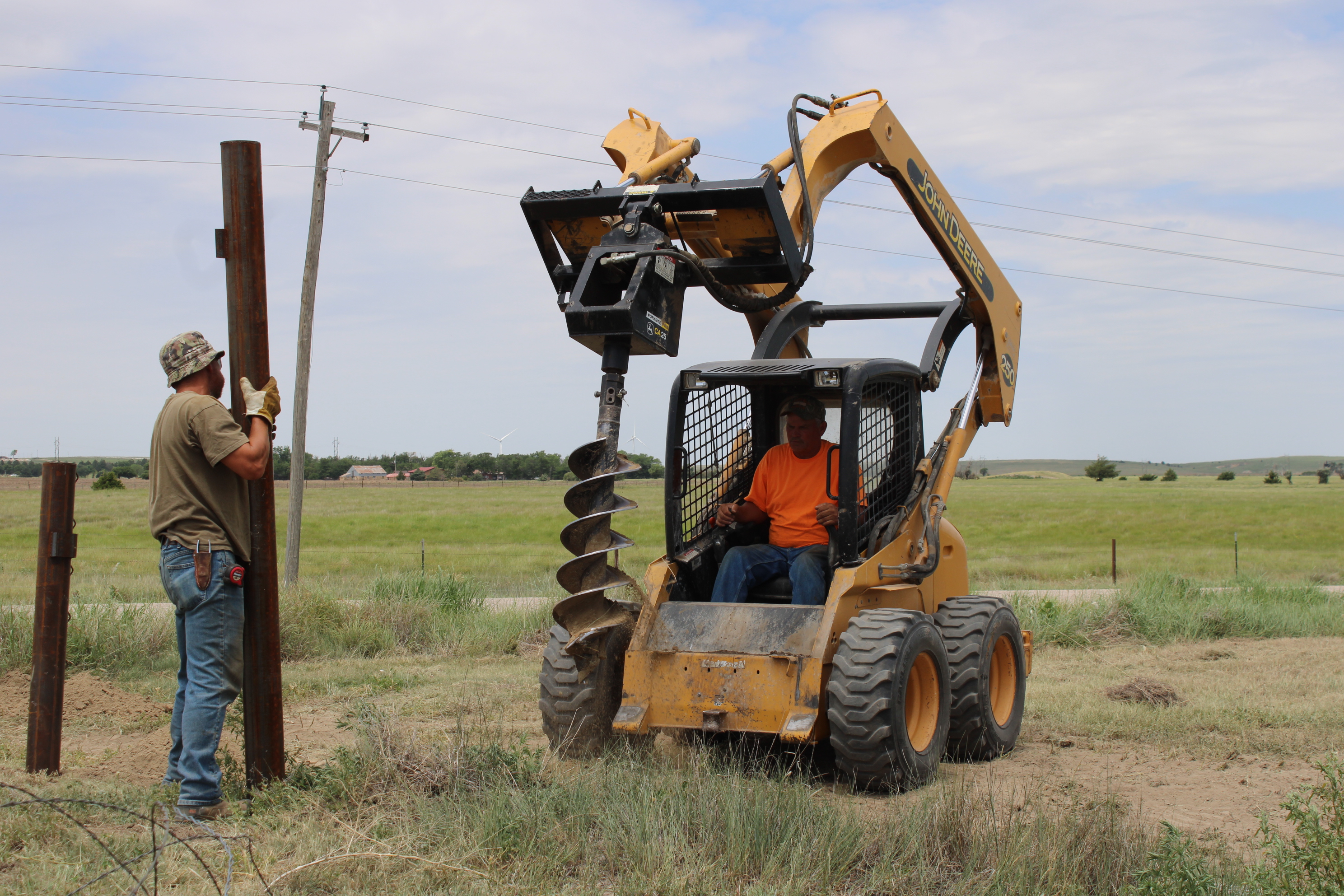 John Dreiling and Chad Jury of J and C Fencing drill post holes and set posts for new University Farm fencing.