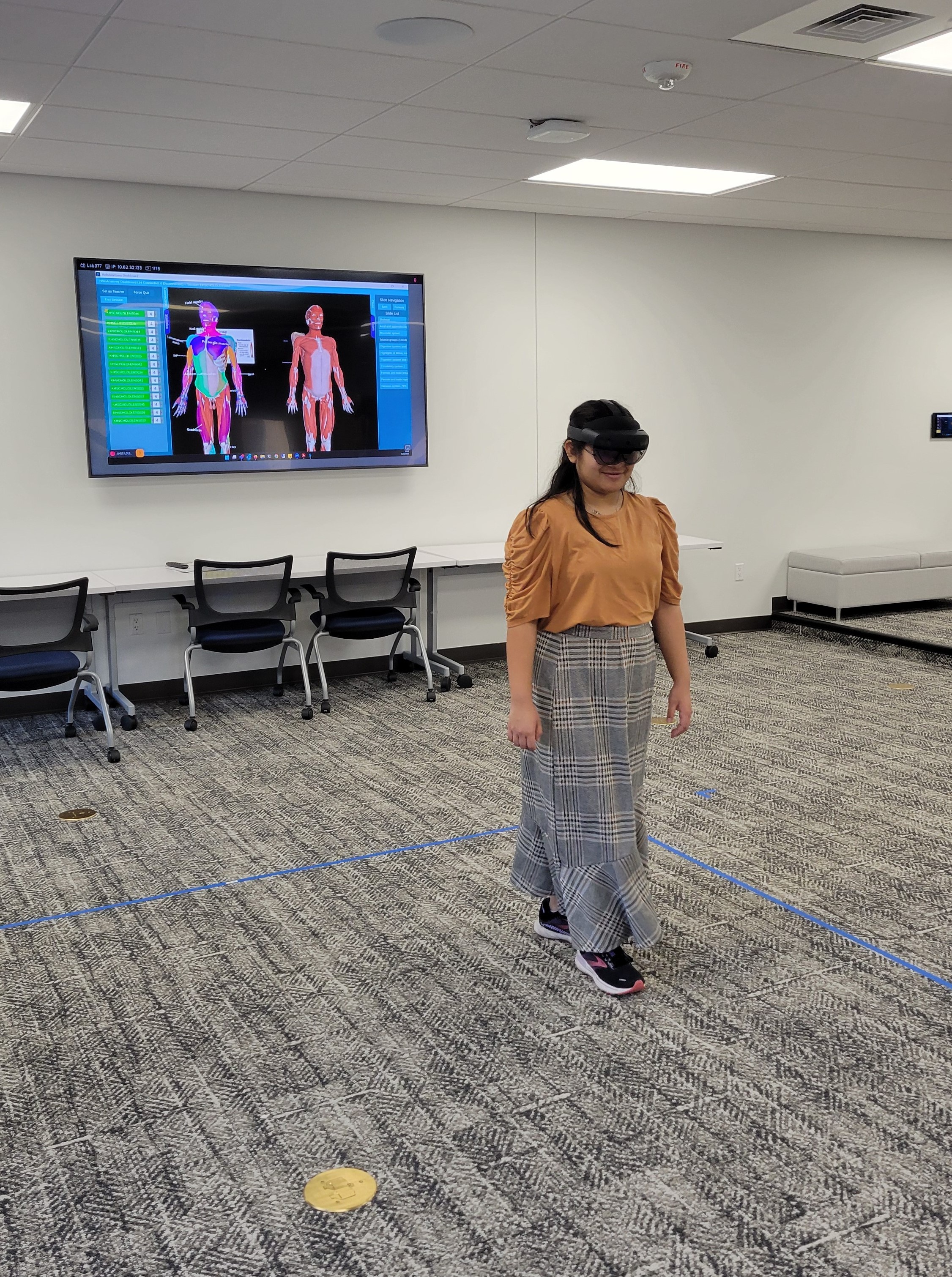 FHSU student, Hailey Maldonado, uses AR goggles to examine 3D hologram of human musculature.