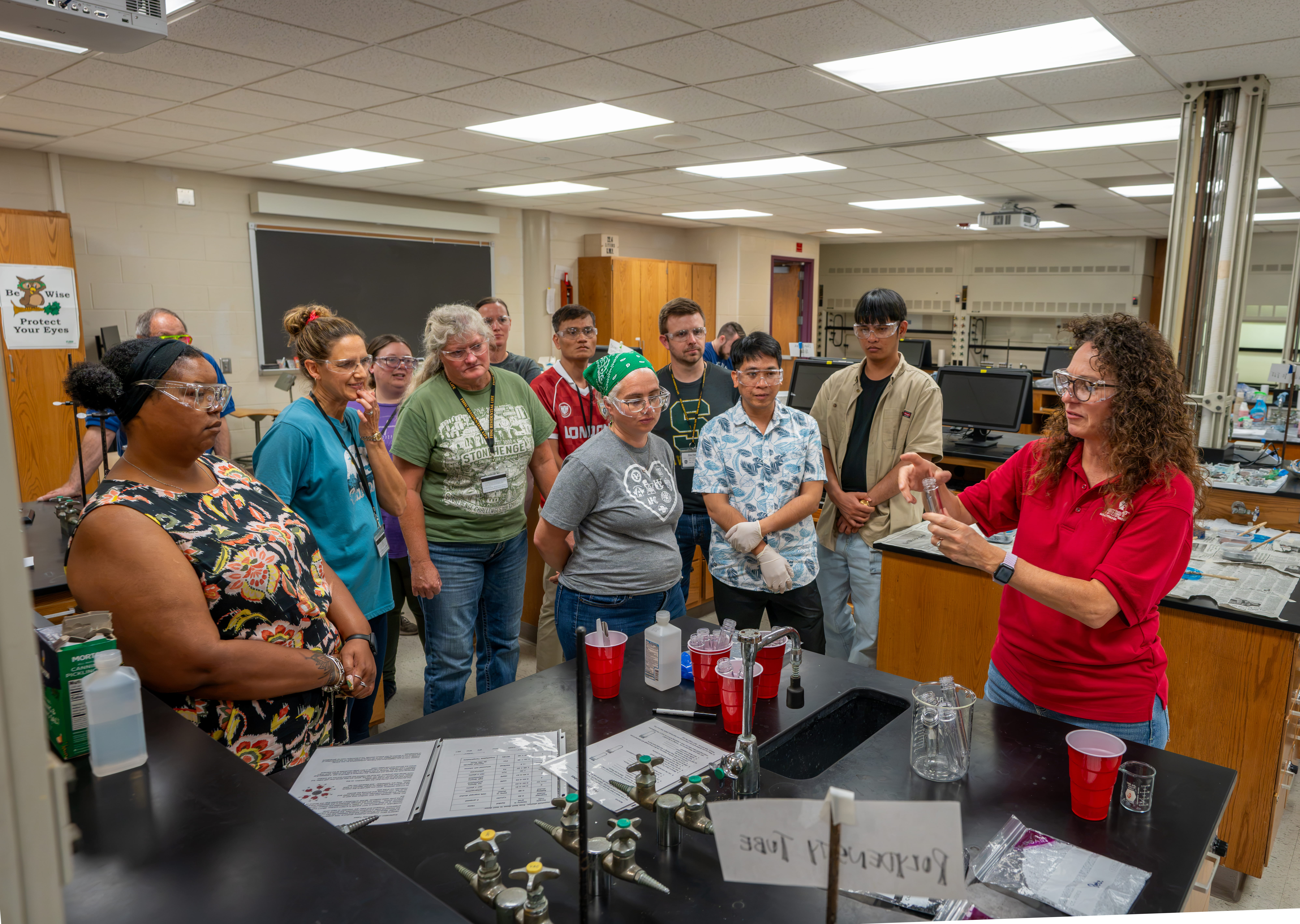ASM camp participants observe a demonstration before performing their own experiments.