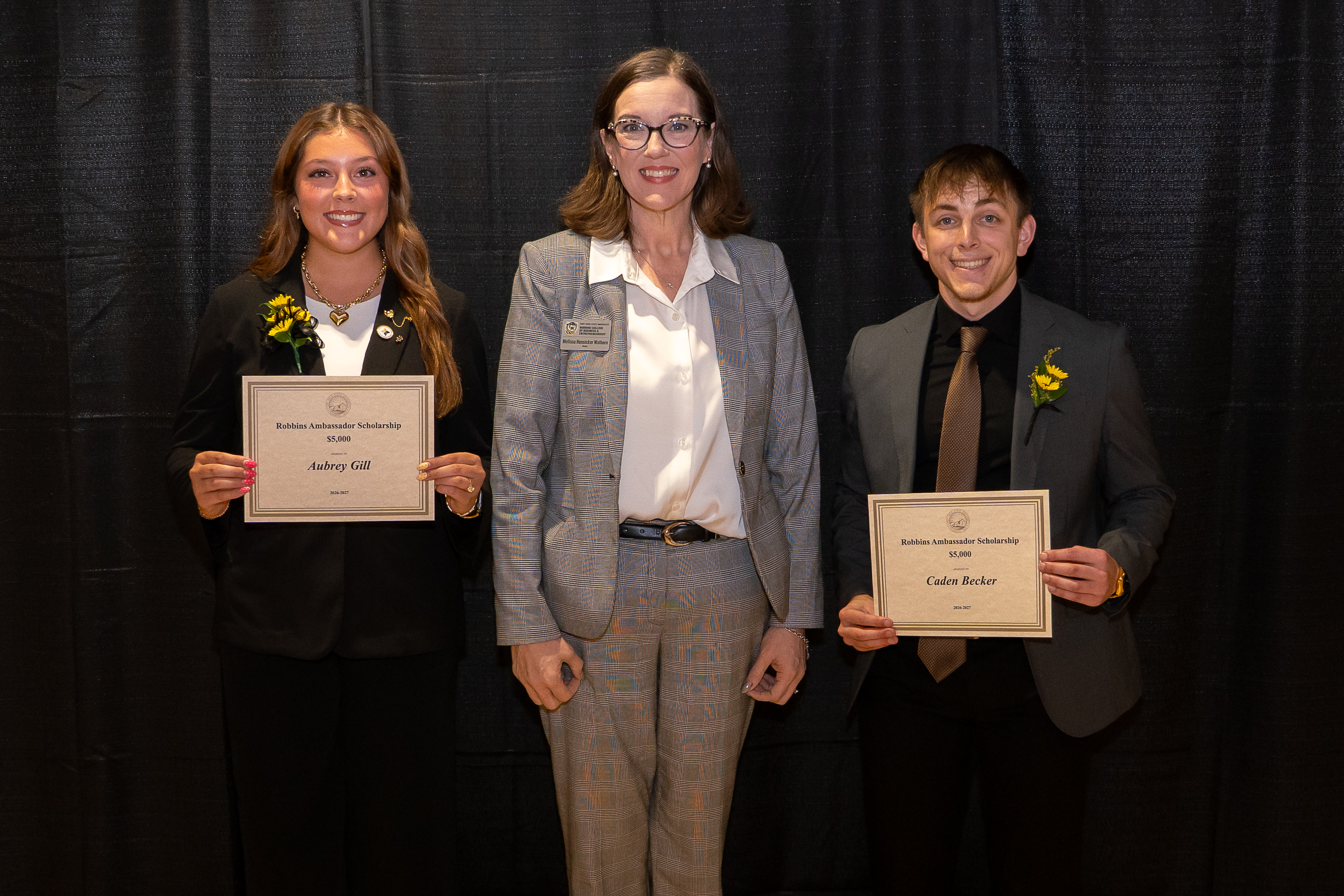 Robbins Ambassadors Aubrey Gill and Caden Becker accepted their scholarship awards from FHSU RCOBE Dean Melissa Hunsicker-Walburn