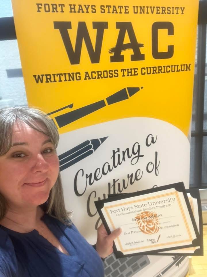 Student taking selfie in front of WAC banner